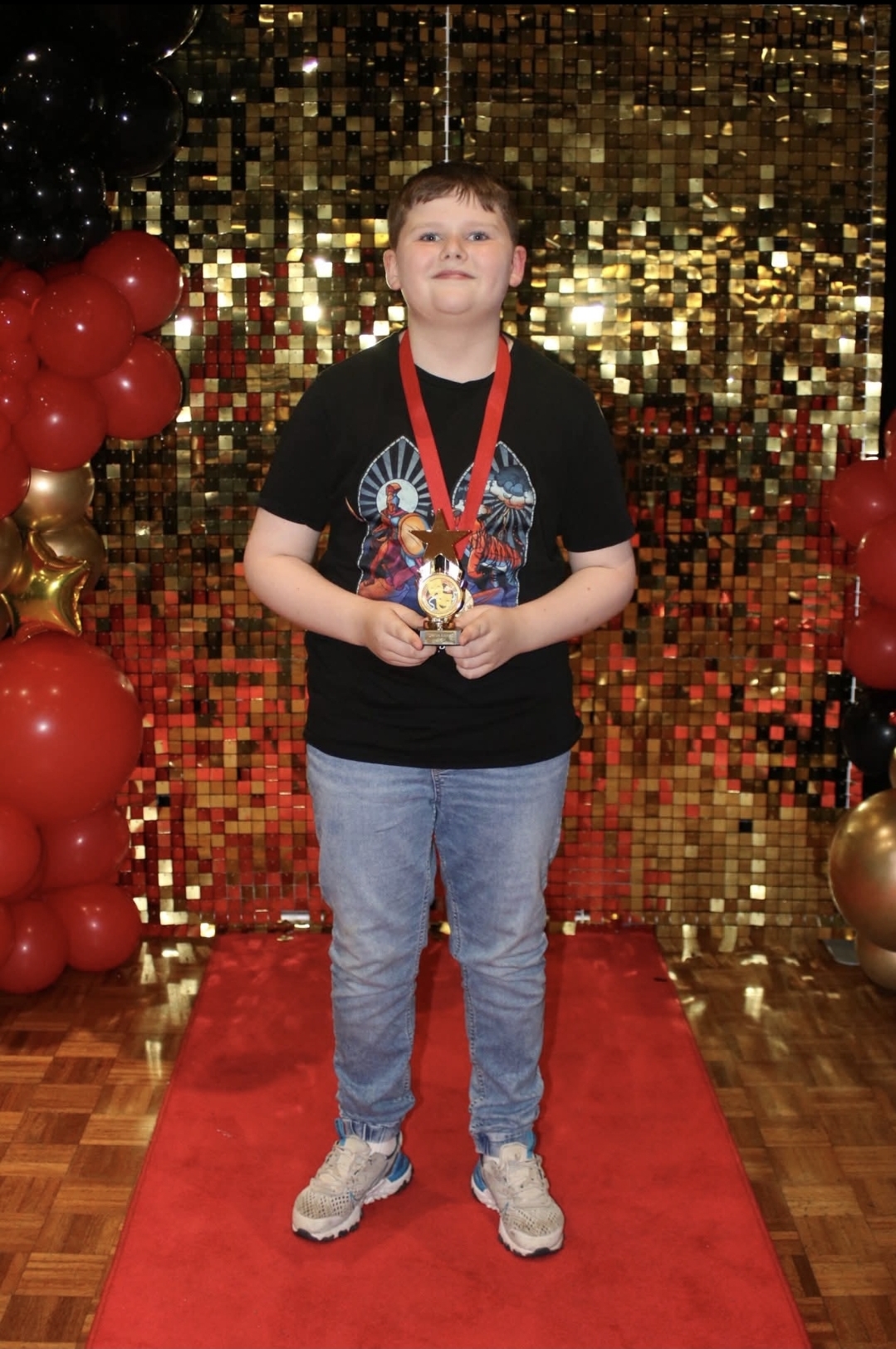 A pupil proudly holding an award